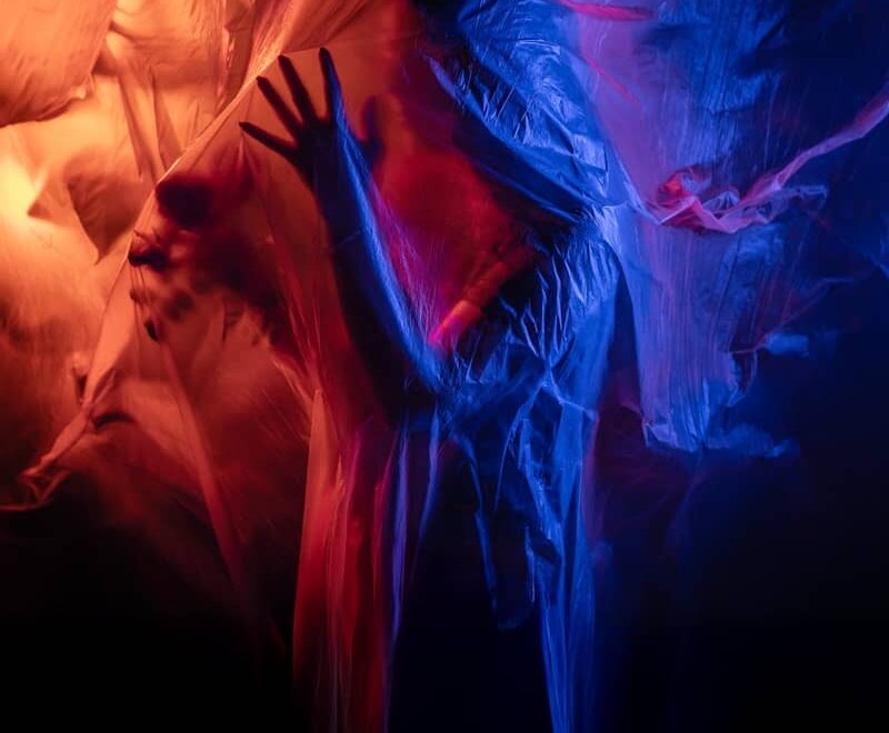 Figure shrouded in translucent fabric with red and blue lights